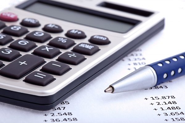 Taschenrechner und Kuli auf Blatt mit Kalkulationen Taschenrechner und Kuli auf Blatt mit Kalkulationen